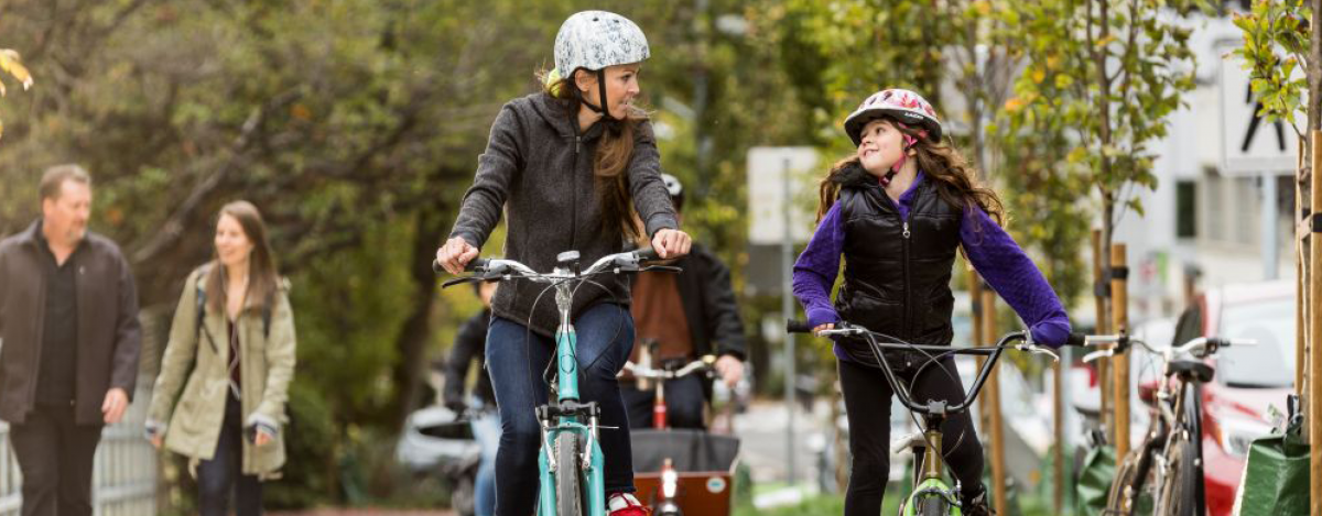 A mother and her daughter cycle on a protected bike lane in Vancouver.