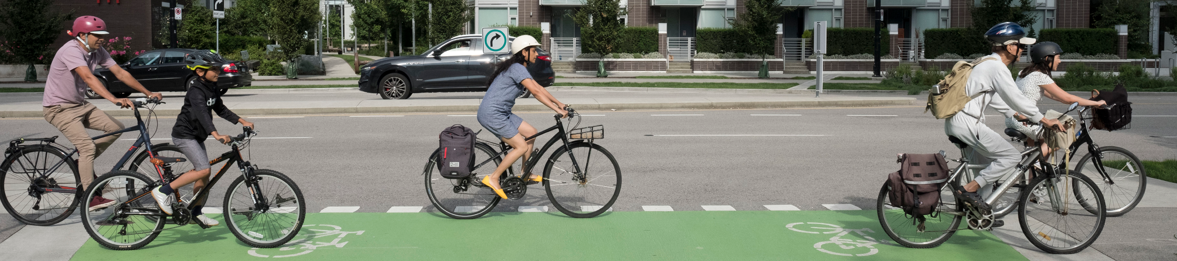 A group of people ride their bikes along a bike lane on Quebec Street in Vancouver