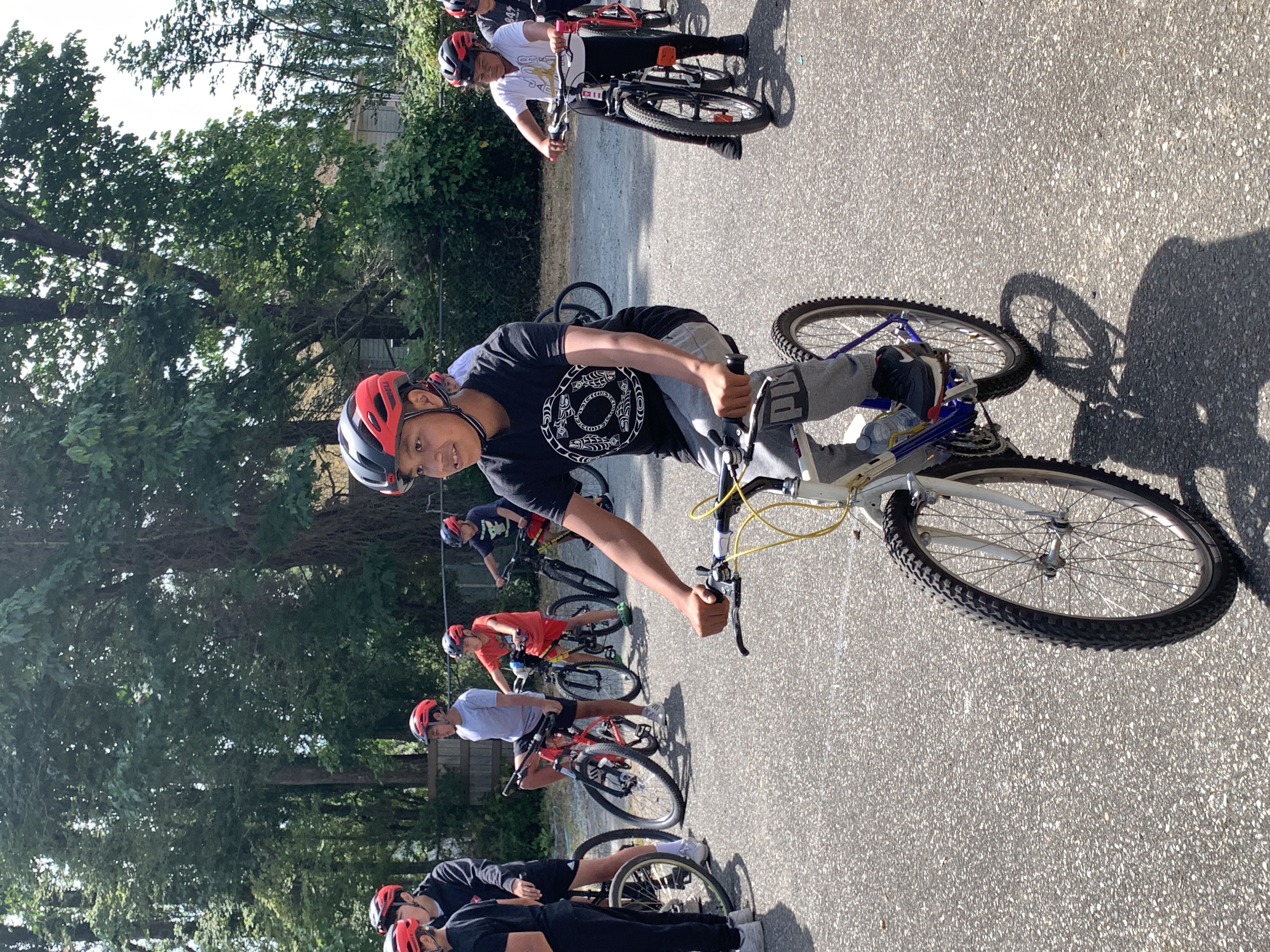 A participant from the Ride Your Path program rides his bike. Several other people ride their bikes behind him.